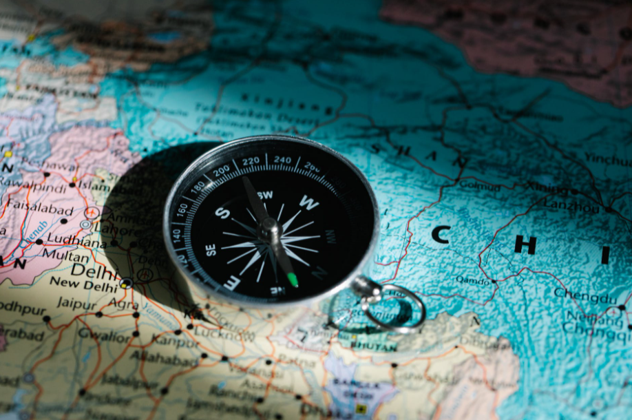A compass laying on a map.