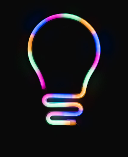 Neon outline of a lightbulb on a black background.